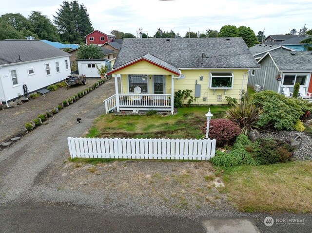 view of front of house with a porch and a storage shed