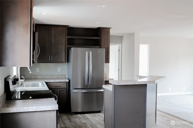 kitchen featuring appliances with stainless steel finishes, a kitchen island, dark brown cabinets, and light hardwood / wood-style flooring