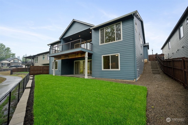 rear view of property with a lawn and a balcony