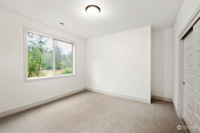 unfurnished bedroom with light carpet and a closet