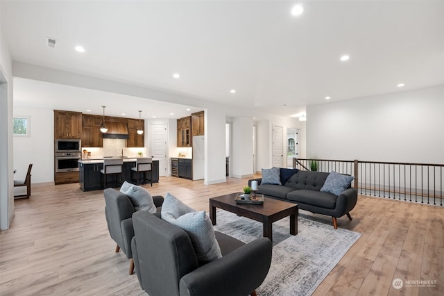 living room featuring light hardwood / wood-style floors and sink