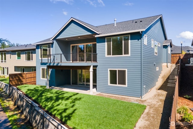 rear view of house featuring a balcony, a patio, and a yard