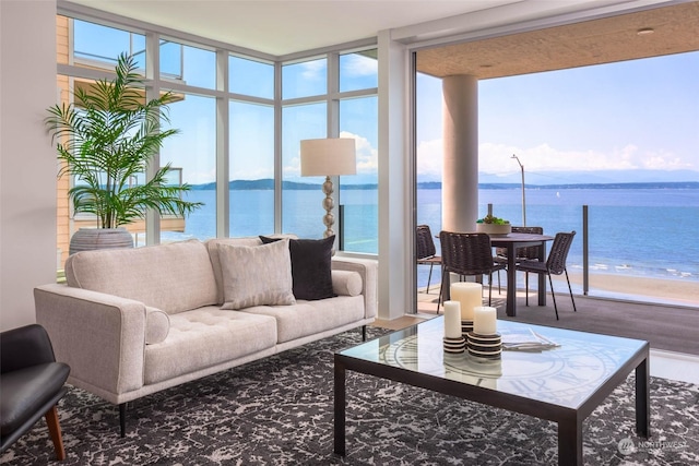 sunroom featuring a water view and a beach view