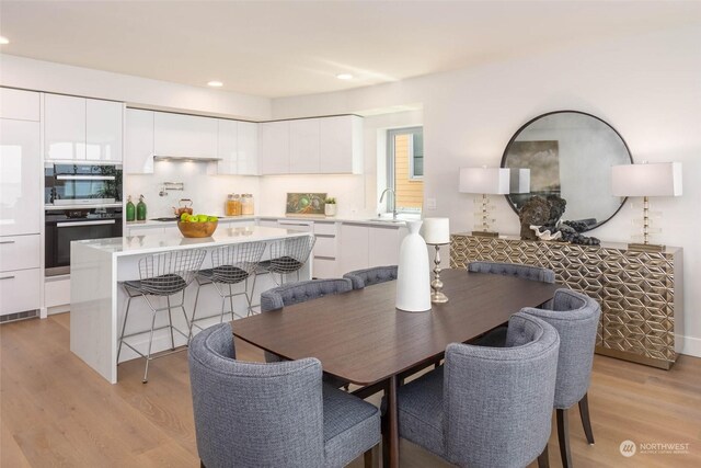 dining area with light hardwood / wood-style floors and sink