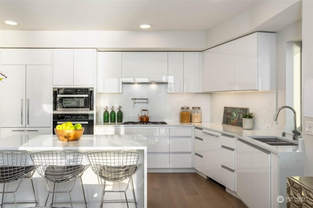 kitchen featuring dark wood-style floors, light countertops, white cabinetry, a sink, and modern cabinets