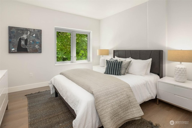 bedroom with baseboards and wood finished floors