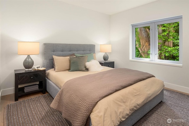 bedroom featuring wood finished floors and baseboards