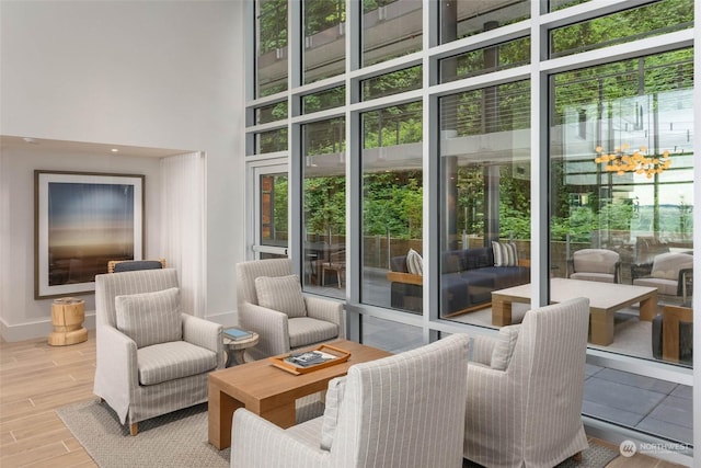 interior space with baseboards, a high ceiling, and wood finished floors