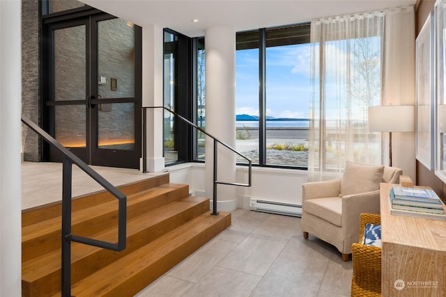 interior space with a baseboard radiator, a water view, stairway, and light tile patterned flooring