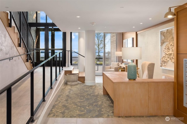 interior space with floor to ceiling windows, stairway, and recessed lighting