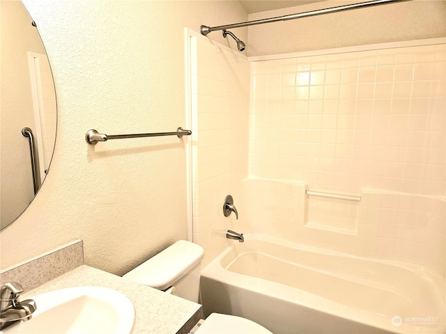 full bathroom with vanity, tiled shower / bath combo, and toilet