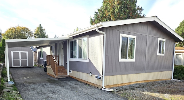 view of side of property with a storage shed and a carport