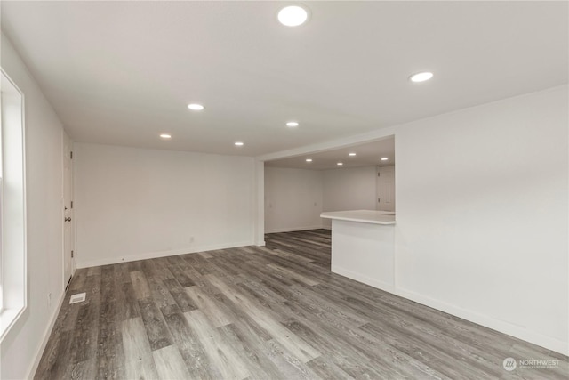 interior space featuring baseboards, wood finished floors, visible vents, and recessed lighting