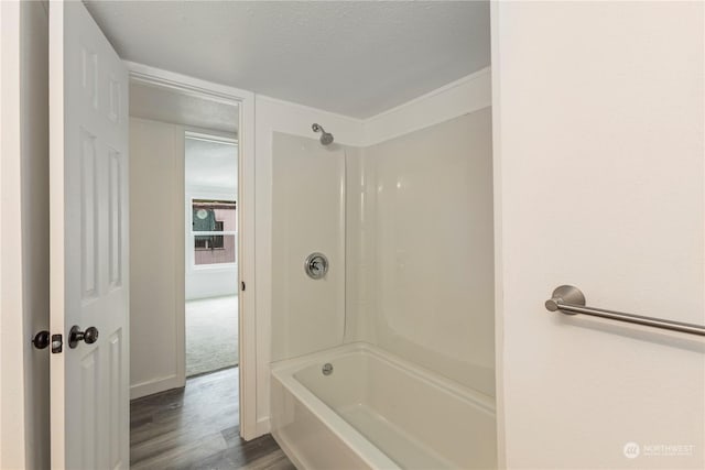 bathroom with a textured ceiling, shower / tub combination, and wood finished floors