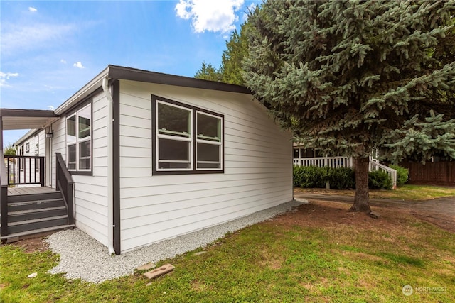 view of property exterior with a yard, a deck, and fence