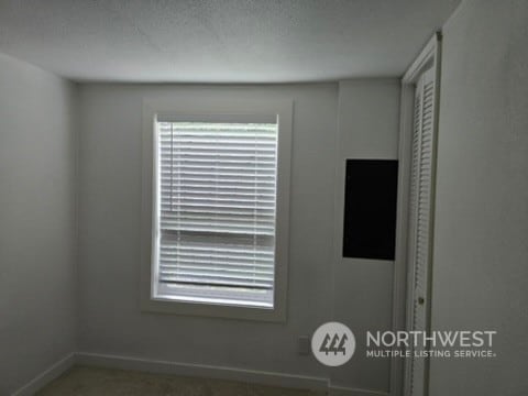 interior details featuring a textured ceiling and baseboards