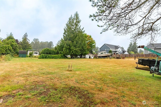 view of yard with a storage shed, fence, and an outdoor structure