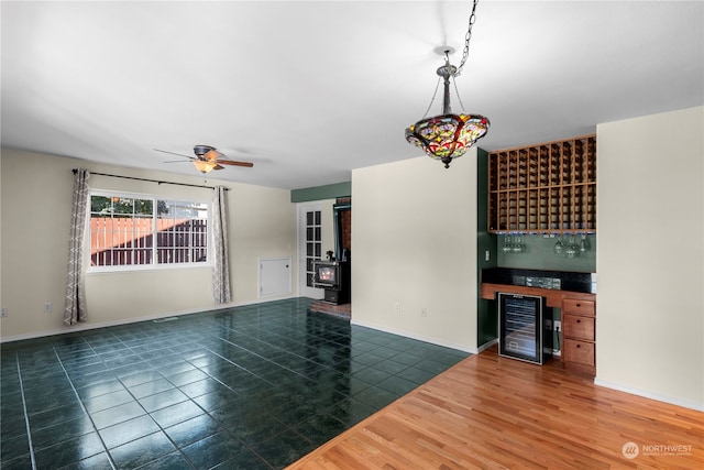 unfurnished living room featuring ceiling fan, beverage cooler, and dark hardwood / wood-style flooring