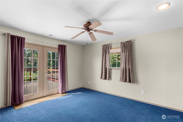 carpeted spare room with a healthy amount of sunlight, ceiling fan, and french doors