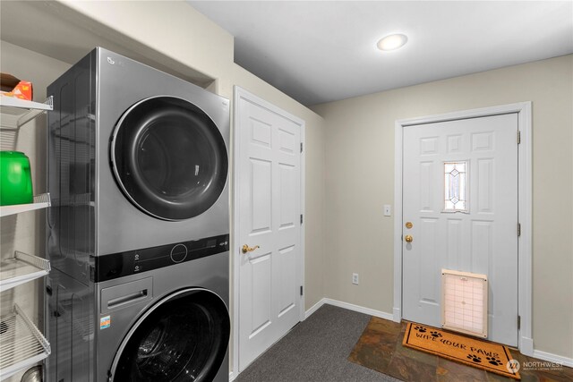 laundry room with carpet flooring and stacked washer / drying machine