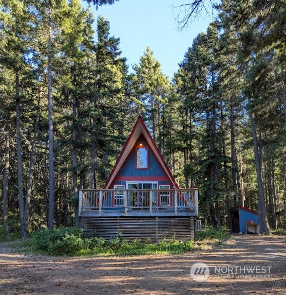 view of front of home with a deck and a storage unit