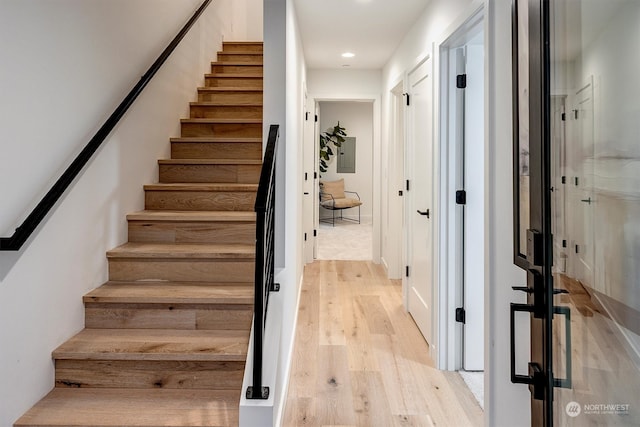 stairs featuring hardwood / wood-style floors