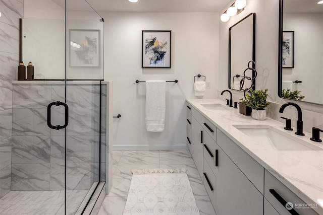 full bath with a stall shower, marble finish floor, a sink, and baseboards