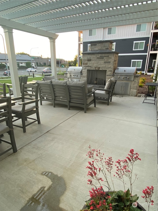 view of patio featuring an outdoor living space with a fireplace, an outdoor kitchen, and area for grilling