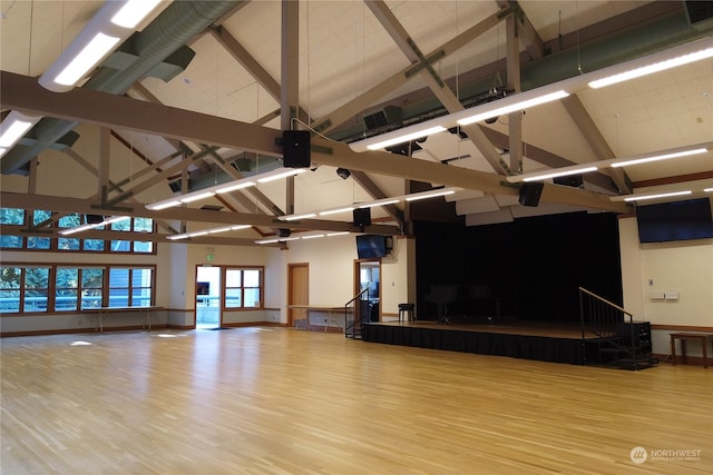 interior space featuring beamed ceiling, light wood-type flooring, and high vaulted ceiling