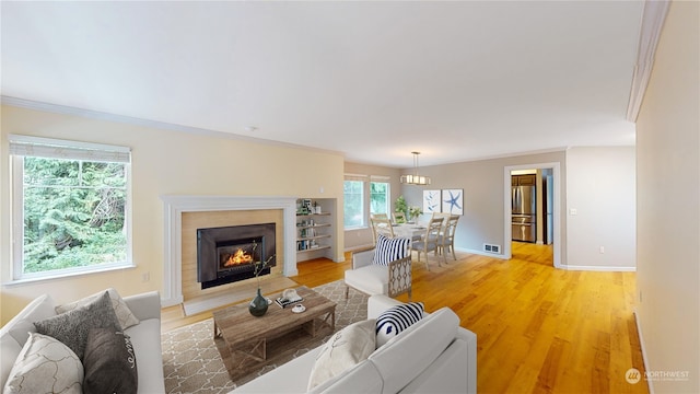 living room with ornamental molding and light wood-type flooring