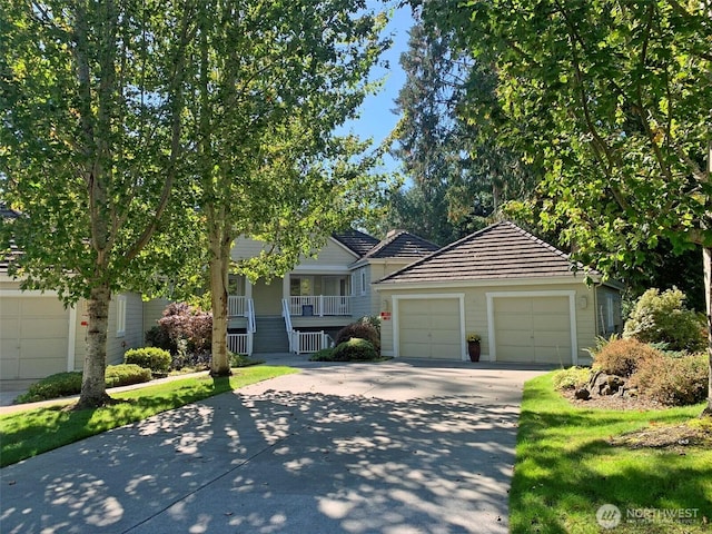 view of front facade featuring a garage, covered porch, stairway, and concrete driveway