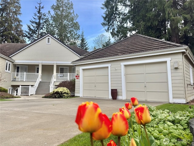 50 S Chandler Ct Unit C, Port Ludlow, WA 98365 - view of front facade with covered porch, an attached garage, and driveway