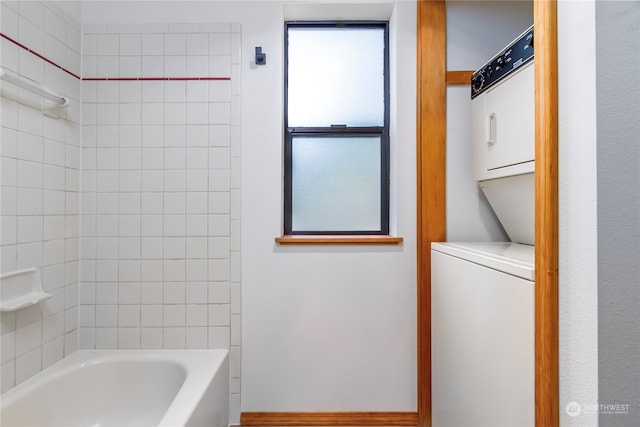 bathroom featuring stacked washer / drying machine and tiled shower / bath combo