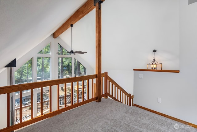 empty room with ceiling fan with notable chandelier, vaulted ceiling with beams, and carpet floors