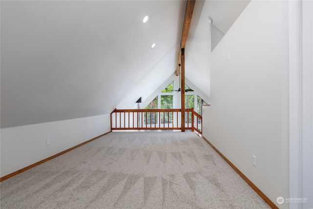 additional living space with lofted ceiling with beams and light colored carpet