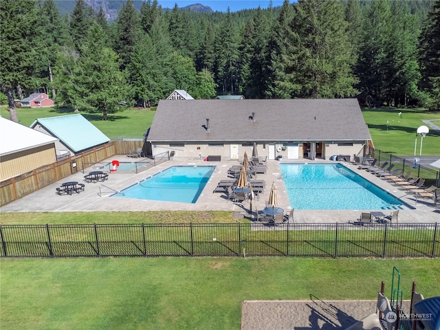 view of swimming pool featuring a lawn and a patio area