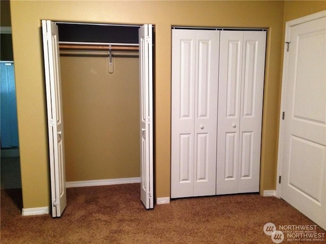 unfurnished bedroom featuring multiple closets, carpet, and baseboards