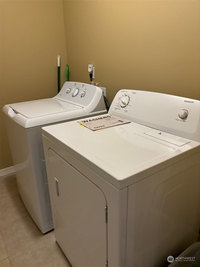 laundry area featuring laundry area, light tile patterned flooring, and separate washer and dryer