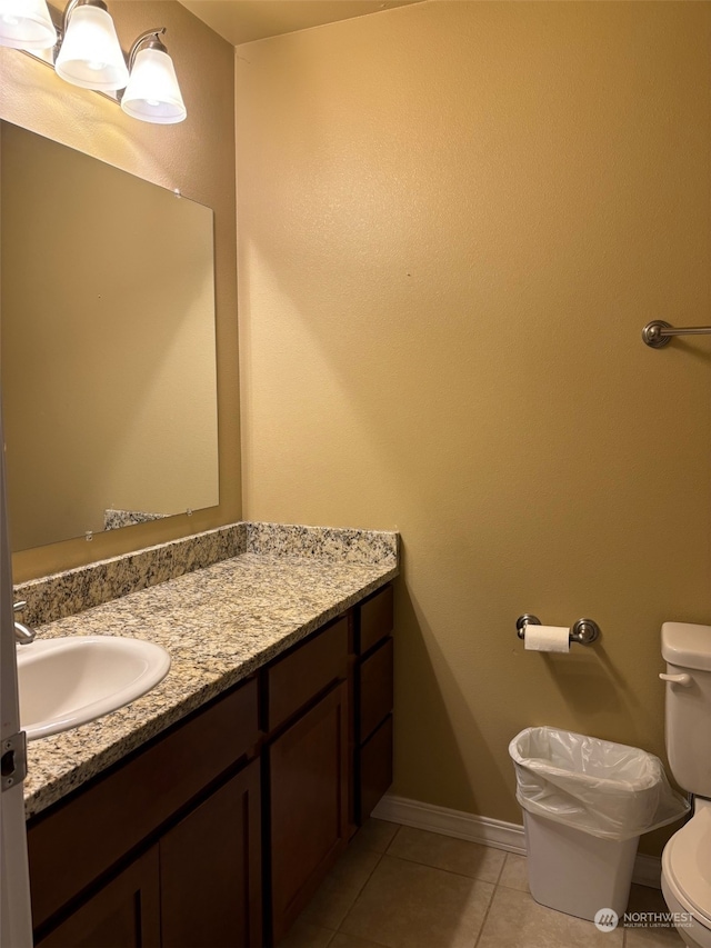 bathroom with toilet, tile patterned flooring, baseboards, and vanity