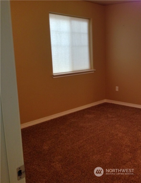 spare room featuring carpet floors and baseboards