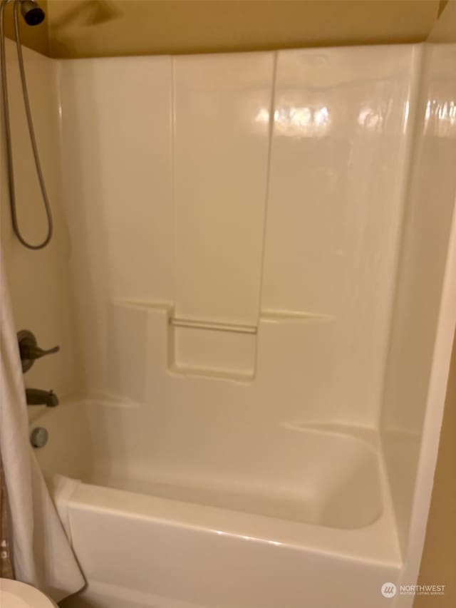 bathroom with shower / bath combo with shower curtain and toilet