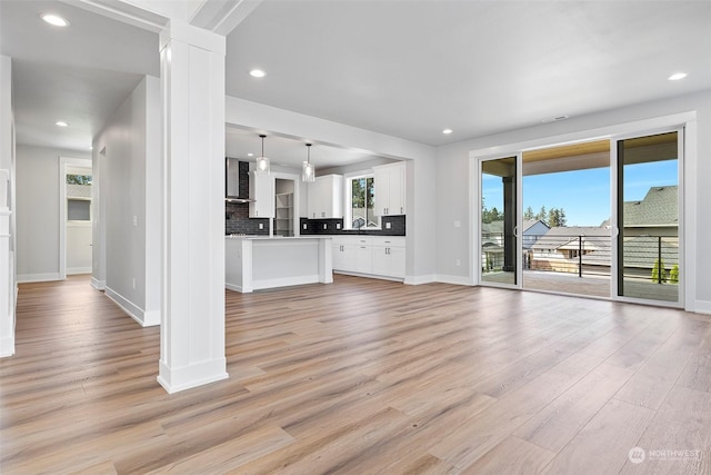 unfurnished living room with light wood-style floors and a wealth of natural light