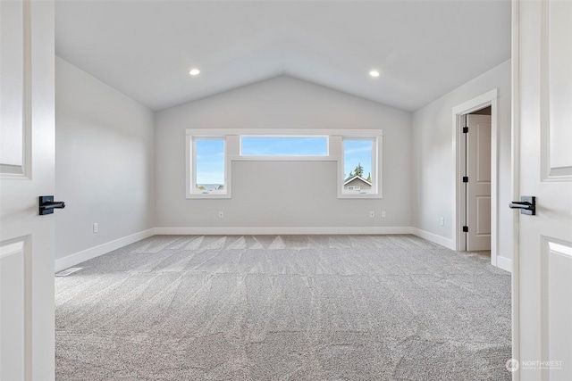 empty room featuring lofted ceiling, carpet floors, recessed lighting, and baseboards