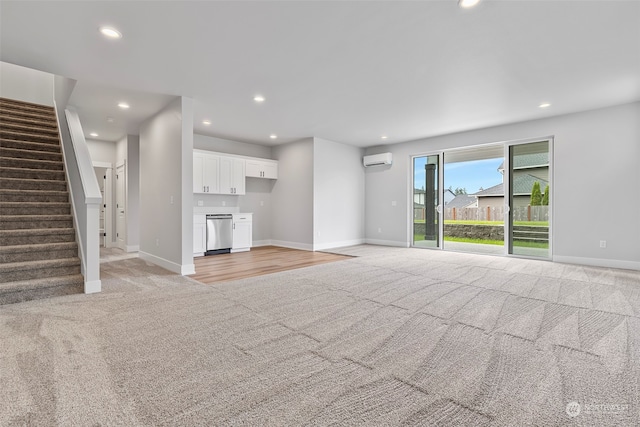 unfurnished living room with a wall mounted AC and light colored carpet