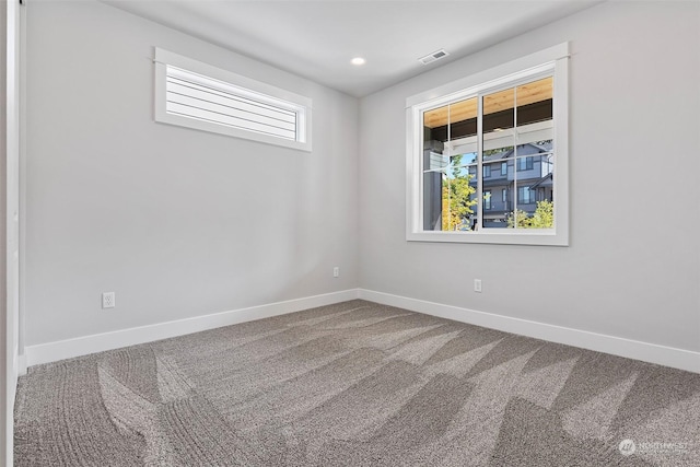 unfurnished room with carpet floors, baseboards, visible vents, and recessed lighting