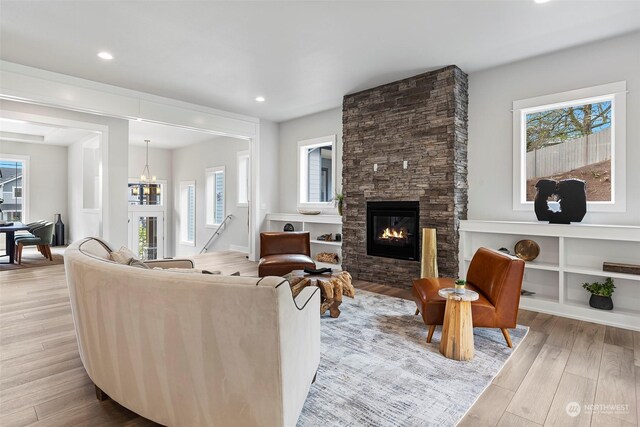 living room with a fireplace, plenty of natural light, and light hardwood / wood-style floors