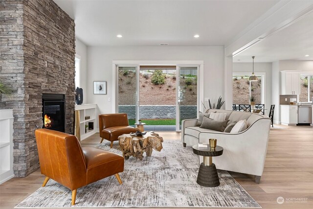 living room featuring light hardwood / wood-style floors and a stone fireplace