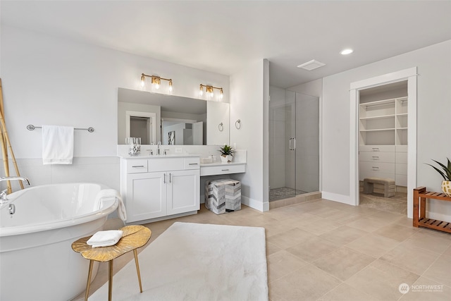 bathroom with plus walk in shower, tile patterned flooring, and vanity