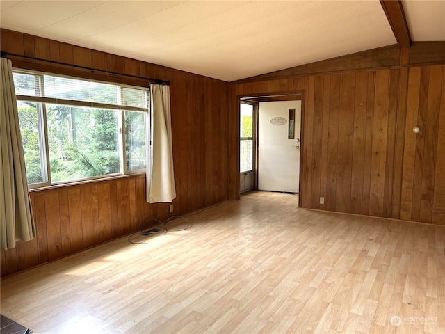 1411 300th Pl, Ocean Park, WA 98640 - empty room featuring wood walls, light hardwood / wood-style flooring, and lofted ceiling with beams