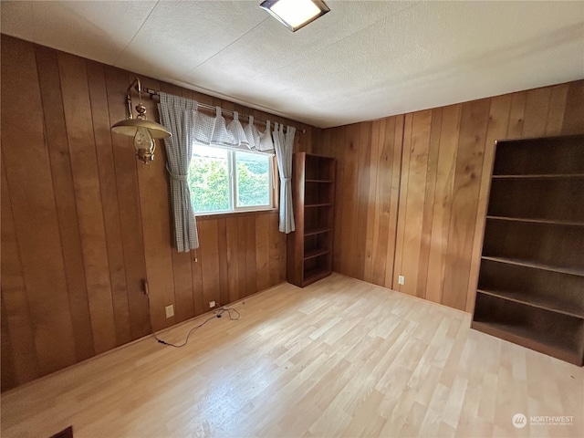 1411 300th Pl, Ocean Park, WA 98640 - unfurnished room featuring wooden walls, a textured ceiling, and hardwood / wood-style floors